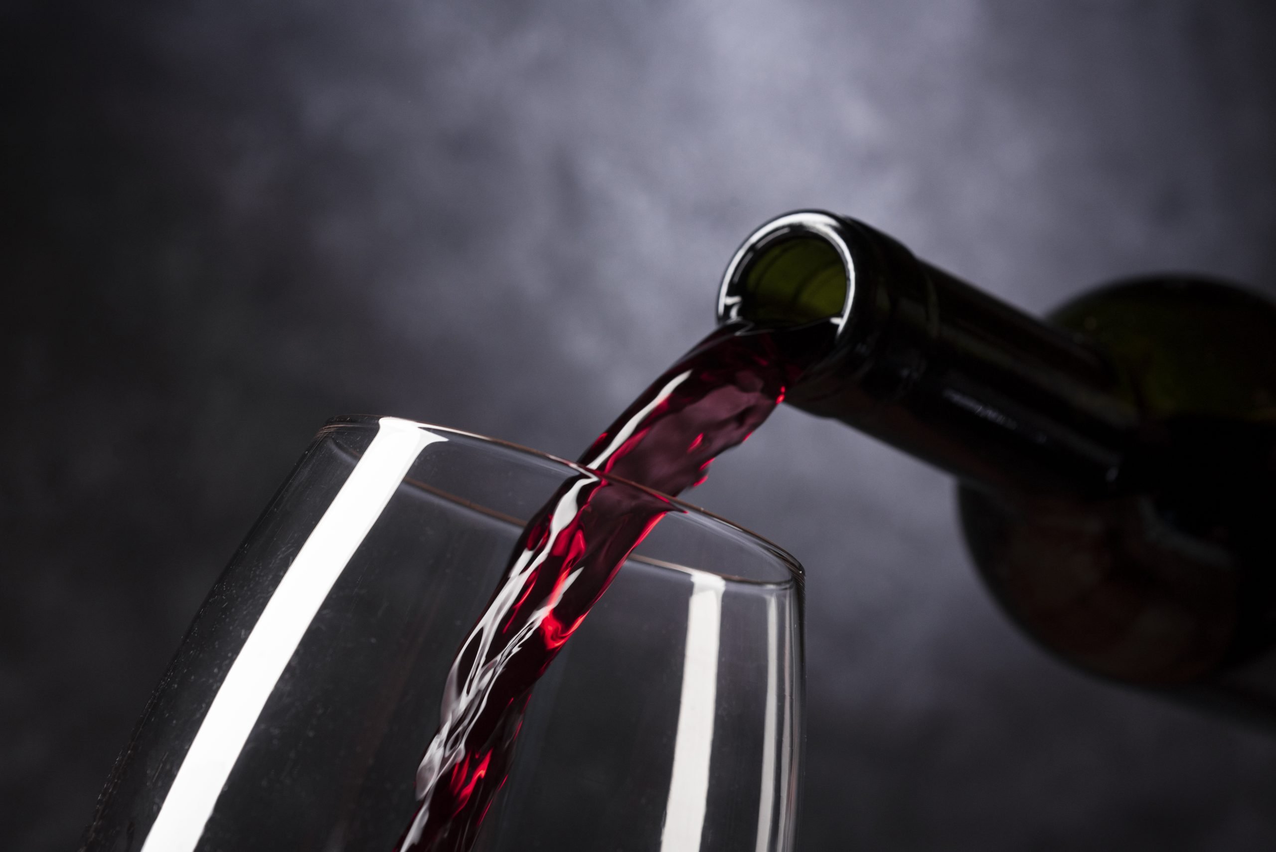 Bottle of red wine pouring into glass. Does red wine really have health benefits?